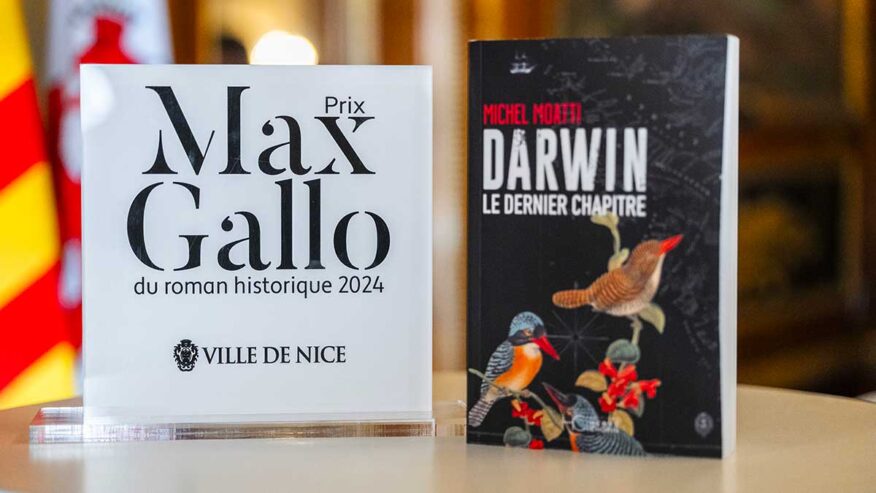 Photo du trophée du prix Max Gallo du Roman historique 2024 (Ville de Nice). À droite du trophée, la couverture du livre "Darwin le dernier chapitre" de Michel Moatti.